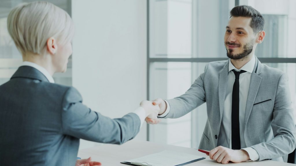 Two professionals shaking hands, representing a client partnership